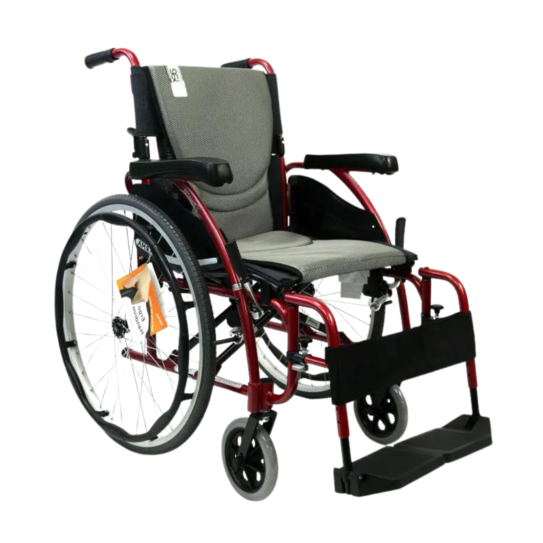 The Karman S-Ergo 125 Wheelchair features a striking red frame, gray S-Shape Ergonomic Seating, black armrests, large rear wheels, smaller front wheels, a convenient footrest, and an ID tag on the left side for easy identification.